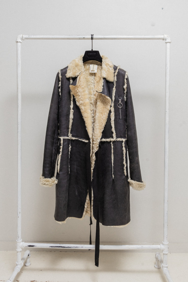UNDERCOVER - FW02 “Witch’s cell division” Long shearling leather coat with waist straps and pocket detail