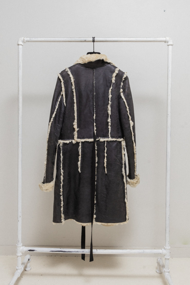 UNDERCOVER - FW02 “Witch’s cell division” Long shearling leather coat with waist straps and pocket detail