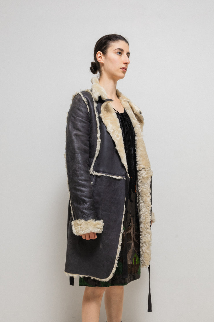 UNDERCOVER - FW02 “Witch’s cell division” Long shearling leather coat with waist straps and pocket detail